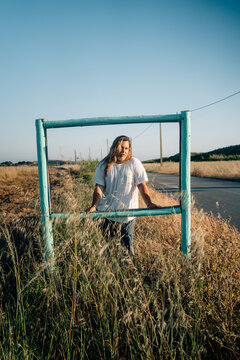 Young Man Posing in a Rustic Frame Near a Country Road