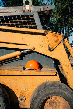 Orange Hard Hat Resting on a Yellow Construction Vehicle