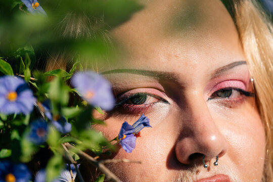 Beauty Portrait Surrounded by Blue Flowers in Natural Light