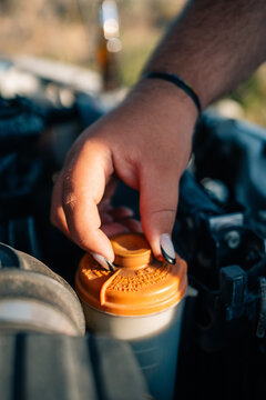 Car Maintenance Task Involving Fluid Reservoir During Daytime