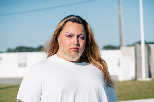 Person With Long Hair Stands Outdoors in Bright Daylight
