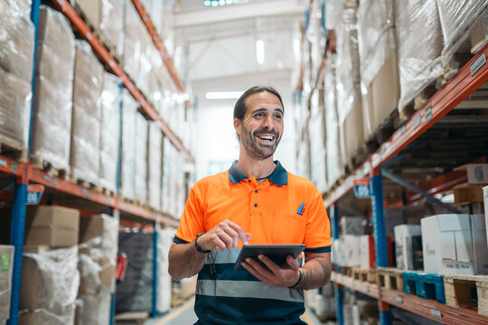 Warehouse worker using digital tablet, managing inventory