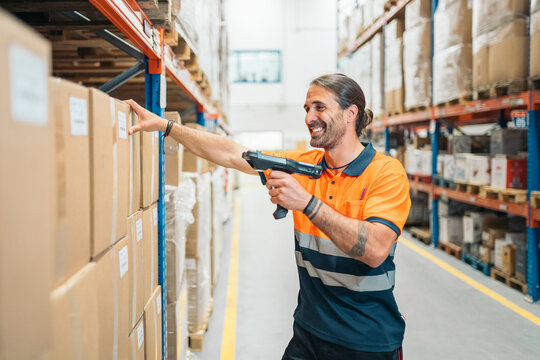 Warehouse worker scanning packages with barcode scanner