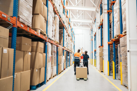 Warehouse workers transporting goods using pallet jack