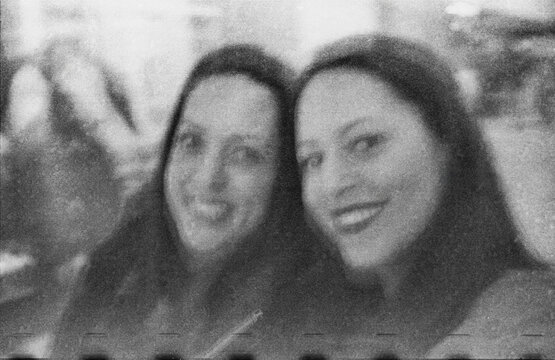 35 mm selfie of two smiling adult sisters close to camera