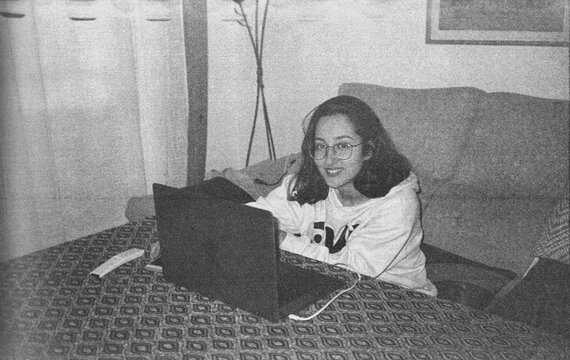 35 mm B&W film photo of teenage girl using laptop at home