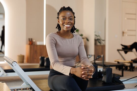 Portrait of smiling black woman looking at camera in fitness studio