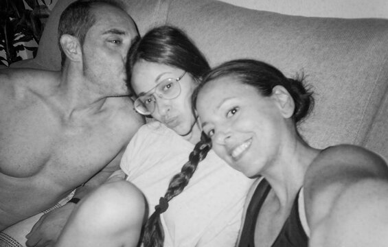 selfie of young parents with teenage daughter on sofa