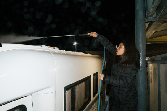 Woman Washing Caravan With Pressure Washer