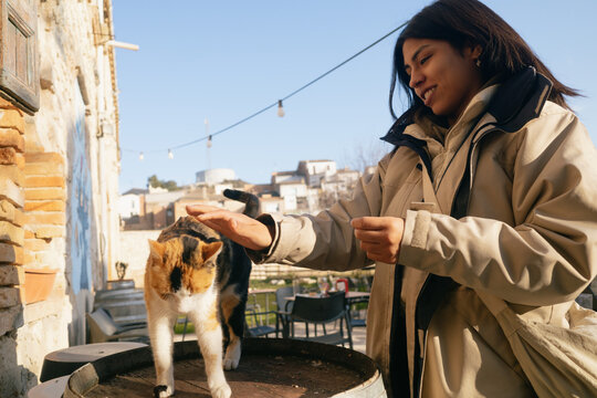 Woman Petting a Cat Outdoors