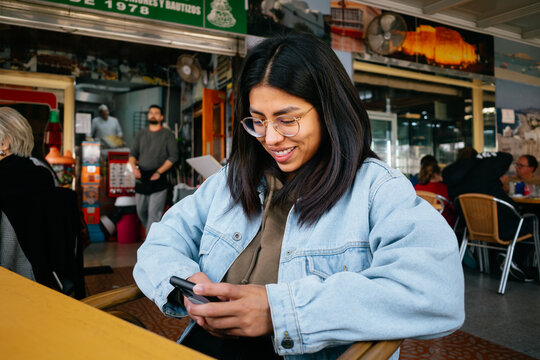Woman Using Smartphone in Cafe