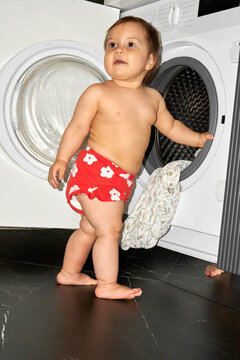 Child Playing Near Washing Machine in a Domestic Setting