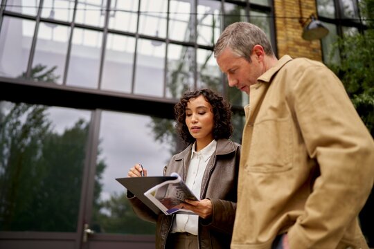 Agent and client discussing property details outside loft building.