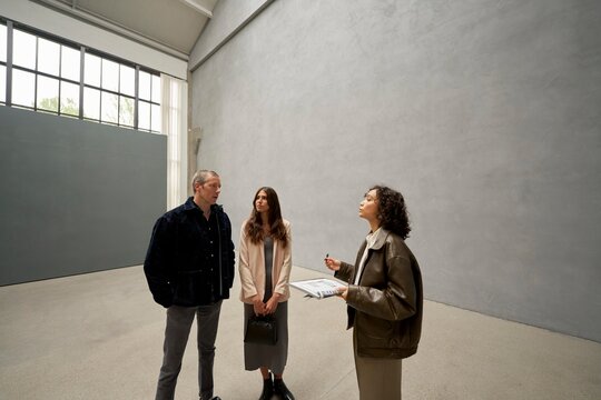 Real estate agent in modern space with potential buyers