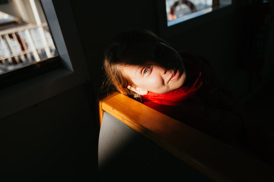 Teenage girl With Striking Blue Eyes in Shadowy Light at Cozy Caf&eacute;