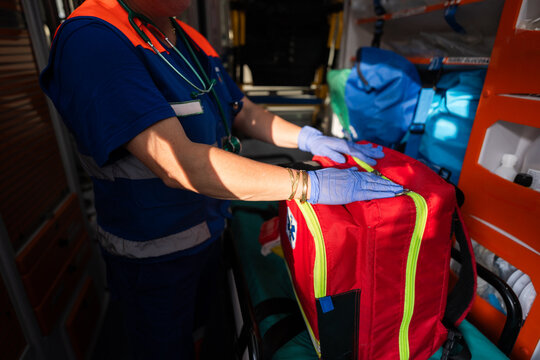 Unrecognizable paramedic preparing first aid kit inside ambulance