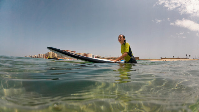 Friends learning to surf, walking with their boards