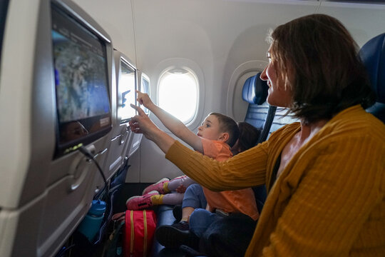 Family traveling on airplane use in-flight entertainment