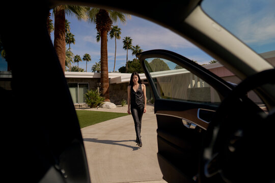 Woman Walks Towards Modern House in Sunny Location in California