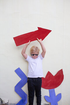 Boy with cardboard flower, zigzag and arrow 