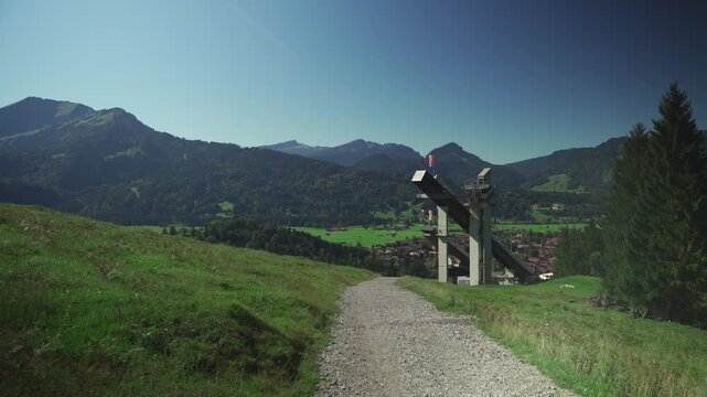 World famous Ski Jump Arena in Oberstdorf Germany. Skiflugschanze Bayern. View of ski jumping hill Audi Arena, part of famous Four Hills Tournament, on sunny day in summer with Allgau mountains. 
