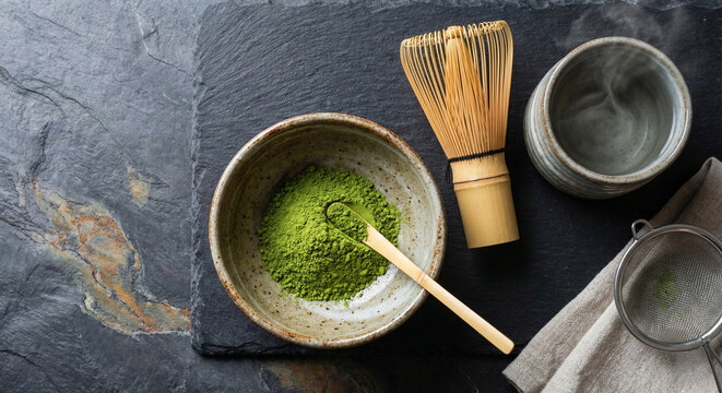 Composici&oacute;n de preparaci&oacute;n de t&eacute; matcha con polvo verde, batidor de bamb&uacute; y cuenco.