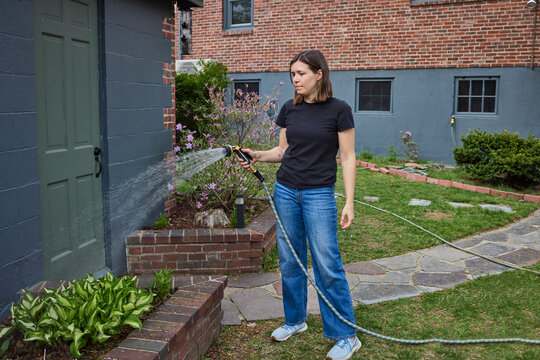 Woman watering plants in the backyard