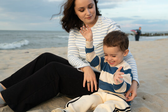 Mother and Child Playing with Sand on the Beach

