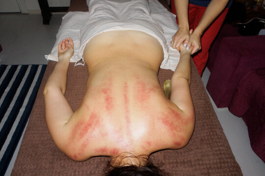 masseur giving massage to young woman
