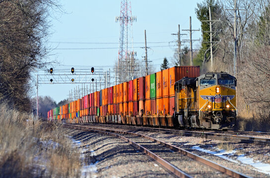 An eastbound Union Pacific intermodal freight train passes uder a signal bridge while traveling through a western Chicago suburb bound for the railroad's Global 2 facility.