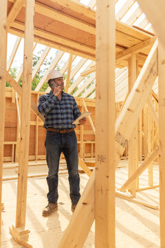 Home Construction Site builder with cell phone 