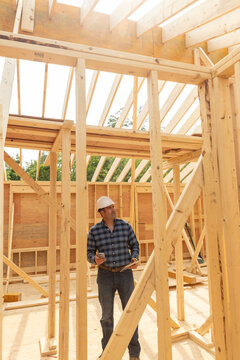 House Construction Site builder hold cell phone 