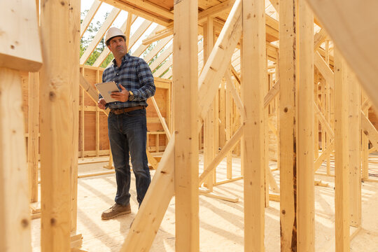 House Construction Site builder hold tablet comptuer 