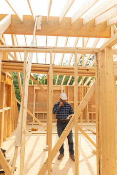 House Construction Site builder talking cell phone 