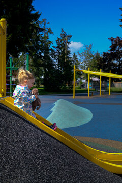 toddler on yellow slide