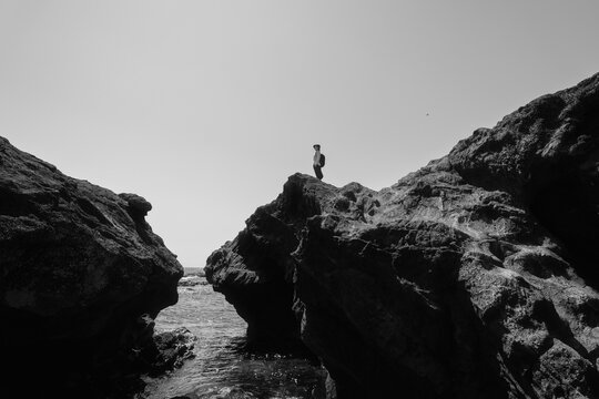 A woman gazing into the distance from a rocky cliff.