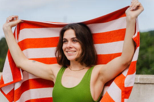 Happy woman shows off a beach towel spread out