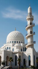 Fototapeta premium Stunning White Mosque with Tall Minaret Against a Clear Blue Sky.
