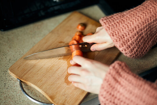 Woman chops carrot, close up