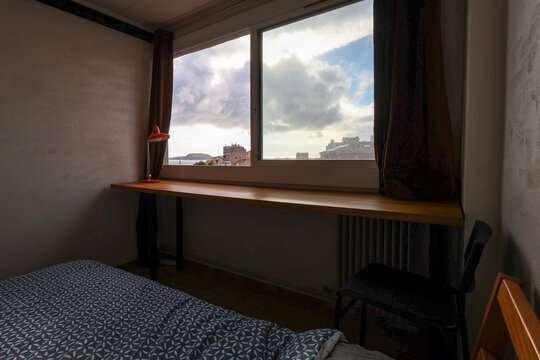 Cozy Bedroom With a View of City Skyline and Clouds