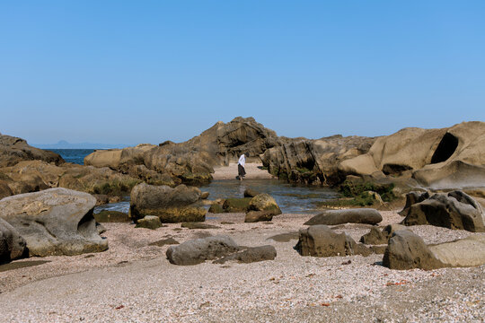 Woman's free exploration on the rocky coast.