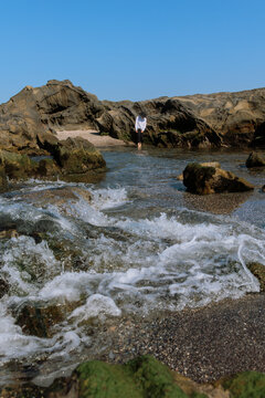 Woman leisurely strolling among the tidal reefs.