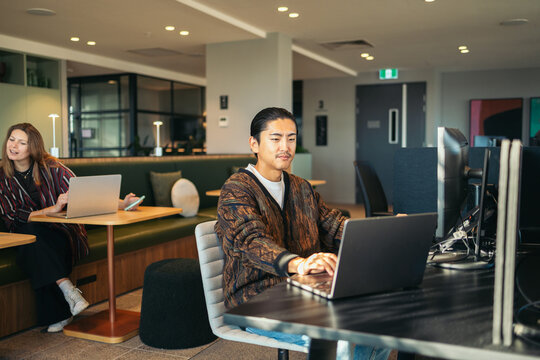 Asian man working at dual screens in the office