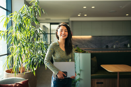 Portrait of smiling Asian woman in coworking lounge