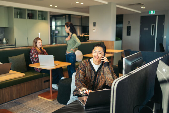 Man taking a phone call while working in coworking space
