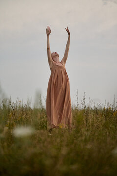 Woman in flowing dress enjoying nature in meadow