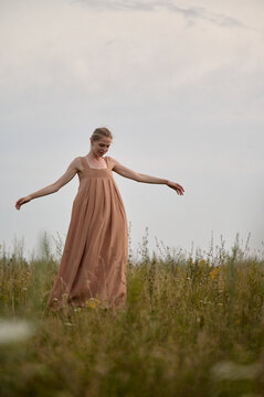 Woman in flowing dress enjoying nature in meadow