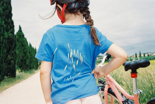 Young Girl Cycling Outdoors. Foxtail grass on back Film