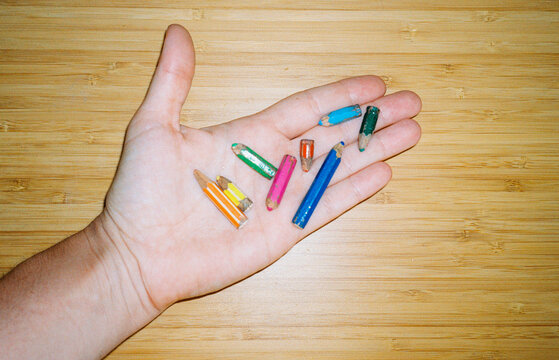 Hand Holding tiny Colorful Pencils. Back to school concept. 