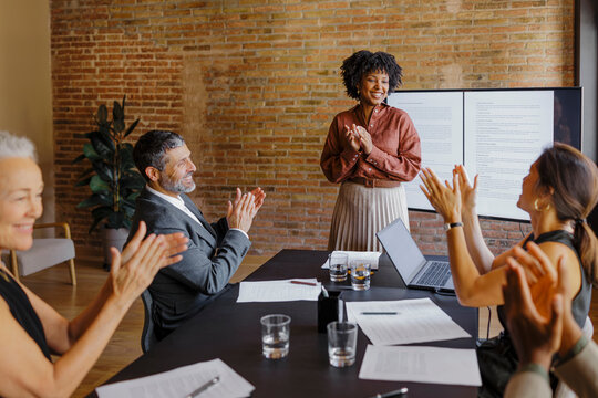 Business team clapping celebrating success in modern office meeting